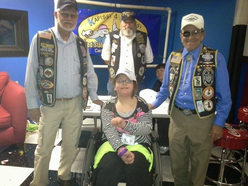Group of people wearing decorated vests.