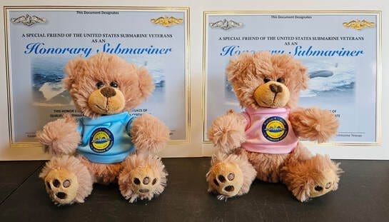 Two teddy bears with honorary certificates.
