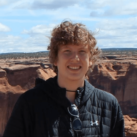 Person smiling in desert landscape background.